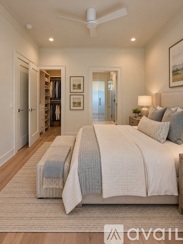 A bedroom with a large bed and a ceiling fan.