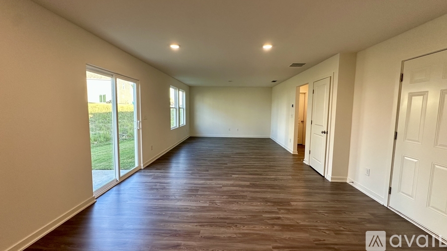 A spacious room with wooden floors and white walls.