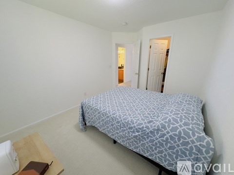 A bedroom with a bed covered in a blue and white patterned comforter.