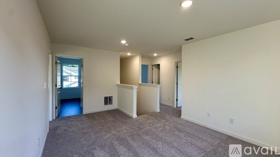 A spacious living room with a carpeted floor and a window.
