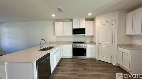 A kitchen with white cabinets and a wooden floor.
