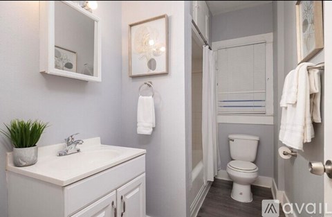 A white bathroom with a toilet, sink, and mirror.