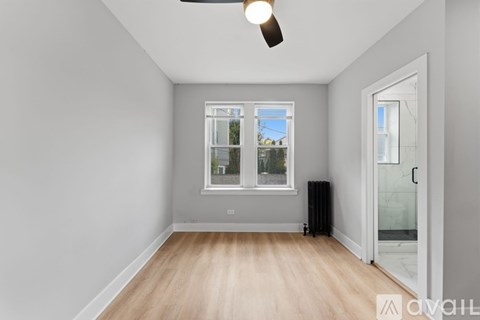 A room with a window and a ceiling fan.