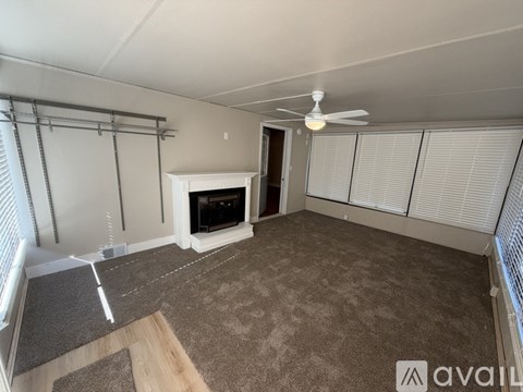A living room with a fireplace and a fan.
