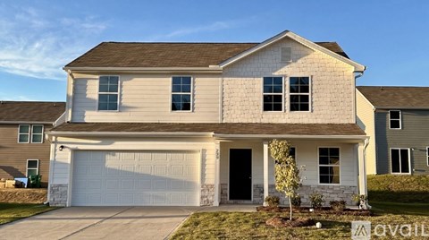 A house with a garage and a driveway in front of it.
