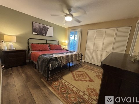 A bedroom with a bed, dresser, and a rug.