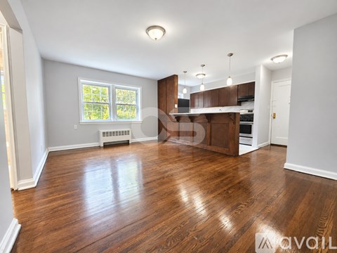 A spacious room with wooden floors and a window.