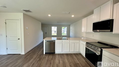 A kitchen with white cabinets and a black stove top oven.
