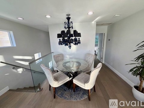A modern dining room with a glass table and chairs.