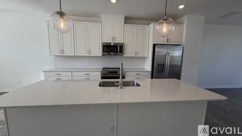 A kitchen with white cabinets and a large island.
