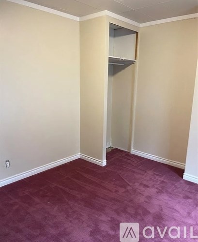 A room with a purple carpet and a white wall.