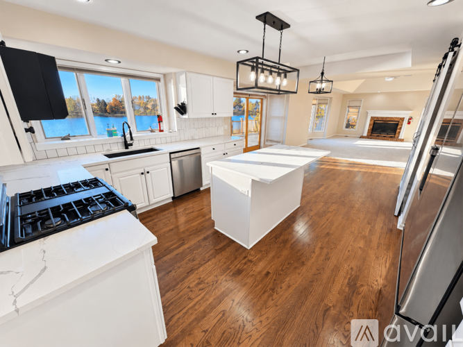 A modern kitchen with white cabinets and a black stove top.