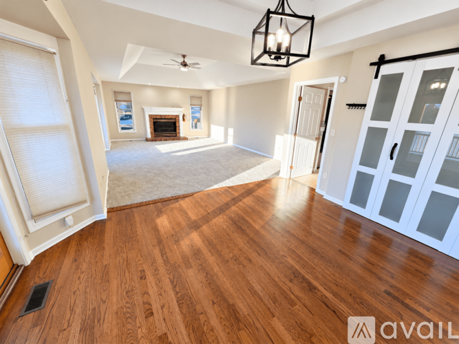 A spacious room with wooden floors and a ceiling fan.