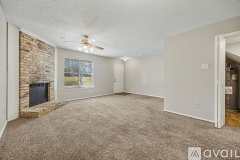 A living room with a fireplace and a ceiling fan.