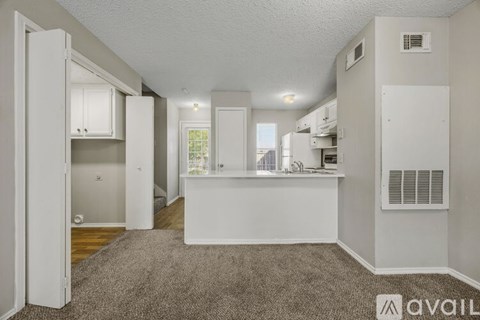 A kitchen area with a white counter and a window.