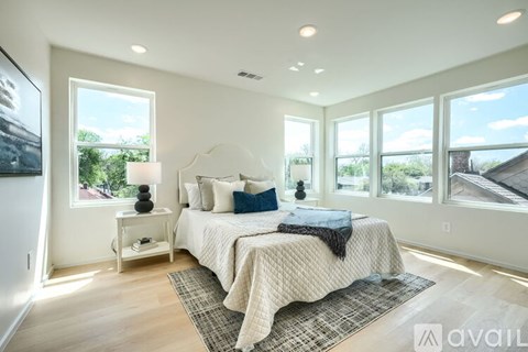 A bedroom with a large bed and a window overlooking a roof.