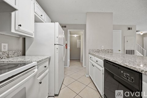 A kitchen with white cabinets and granite countertops.