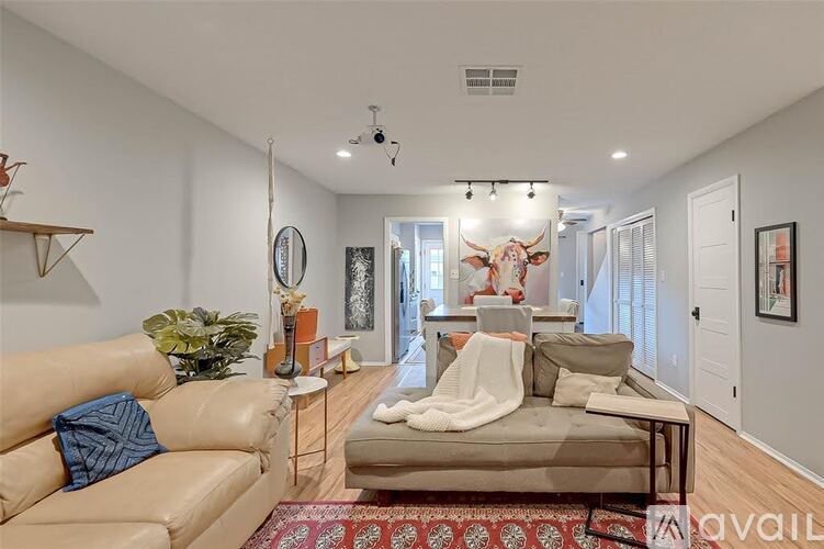 A living room with a tan couch and a white sofa.