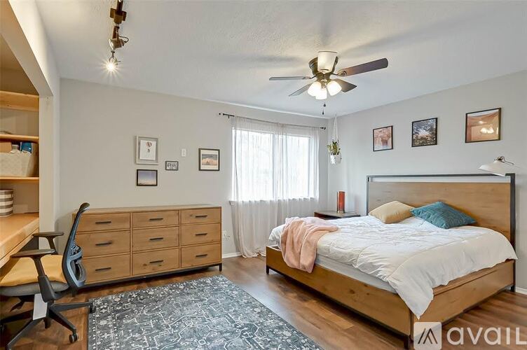 A bedroom with a bed, a desk, and a chair.
