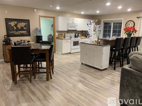 A kitchen with a dining table and chairs.