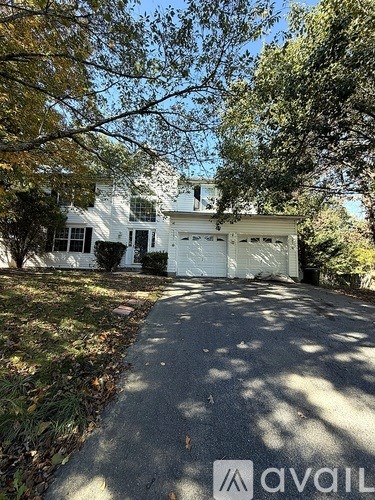 A white house with a driveway in front of it.