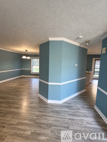 A room with wooden flooring and a blue wall.