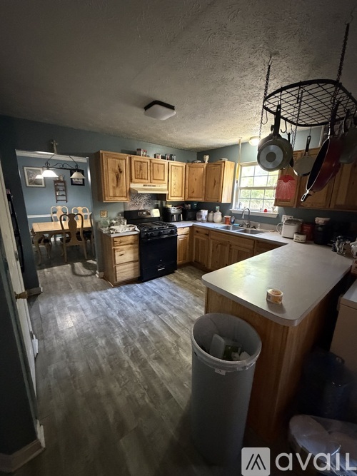 A kitchen with wooden cabinets and a grey floor.