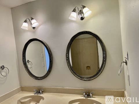 A bathroom with two sinks and two mirrors.