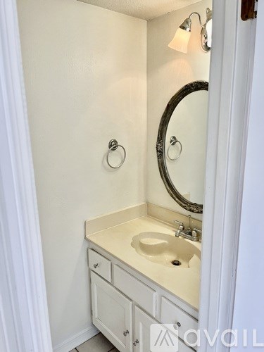 A white bathroom with a sink and mirror.