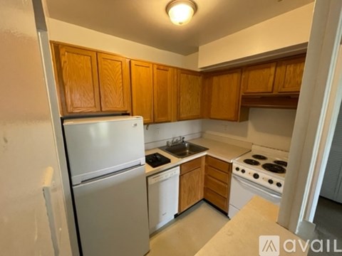A kitchen with wooden cabinets and white appliances.