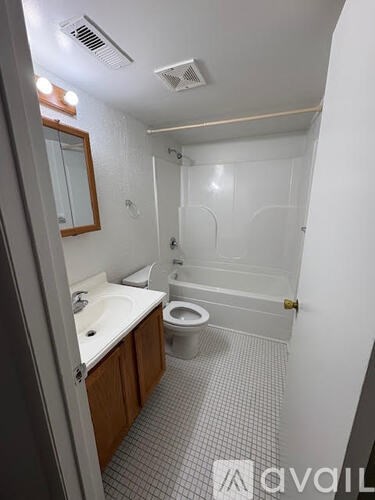 A bathroom with a toilet, sink, and bathtub.