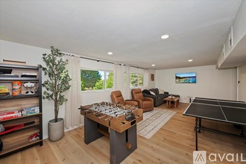 A room with a pool table and a TV on the wall.