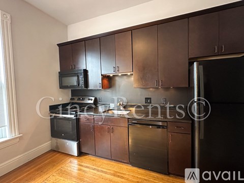 A kitchen with dark wood cabinets and stainless steel appliances.