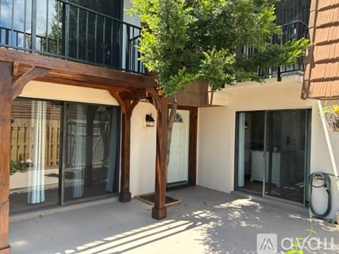A balcony with a wooden pergola and glass doors.