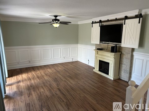 A living room with a fireplace and a television mounted above it.