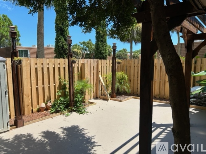 A backyard with a wooden fence and a tree.
