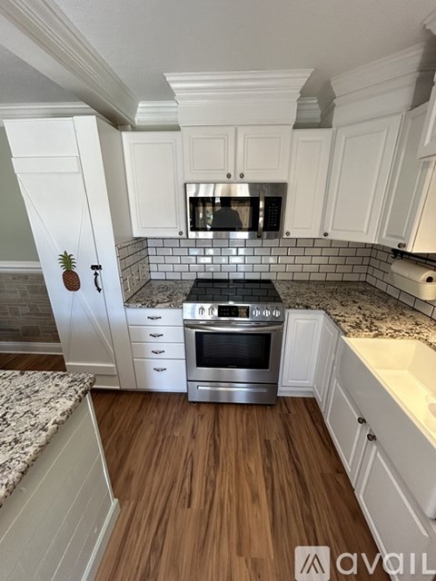 A kitchen with white cabinets and a stainless steel oven.