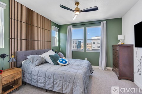 A bedroom with a bed, nightstand, and a ceiling fan.