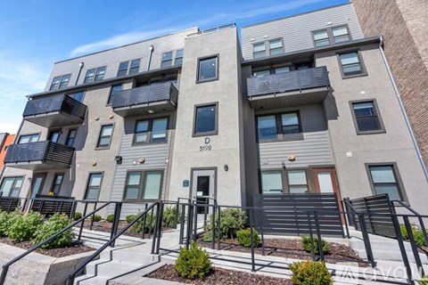 A modern apartment building with balconies and a clear sky.