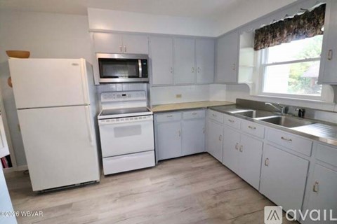 A kitchen with white appliances and cabinets.
