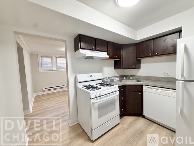 A kitchen with white appliances and brown cabinets.