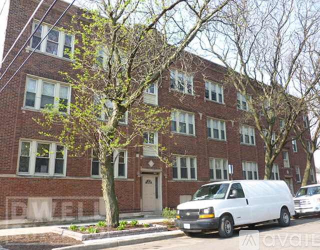 A red brick building with a white van parked in front.