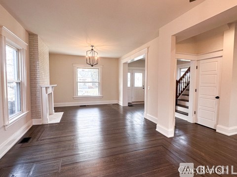 A spacious room with wooden floors and white walls.