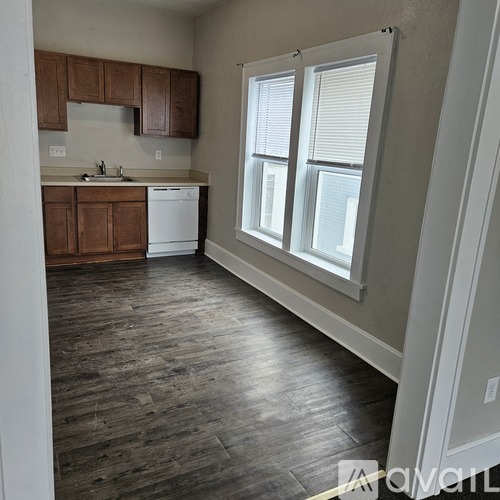 A kitchen with wooden cabinets and a white dishwasher.