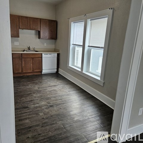 A kitchen with wooden cabinets and a white dishwasher.