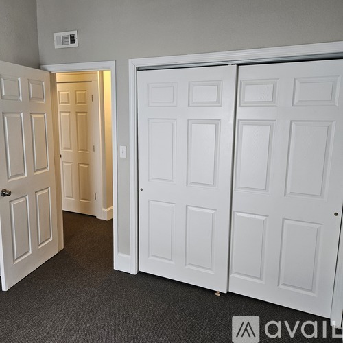 A room with two white doors and a carpeted floor.