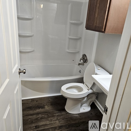 A white toilet in a small bathroom with a walk-in shower.