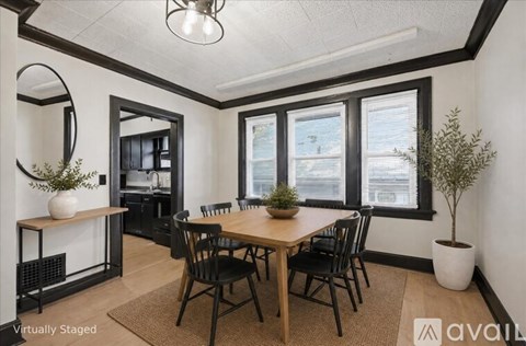 A dining room with a wooden table and chairs.