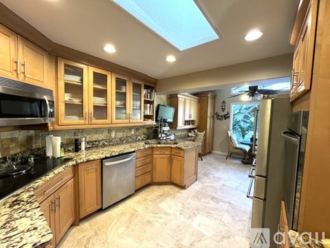 A kitchen with wooden cabinets and a marble countertop.