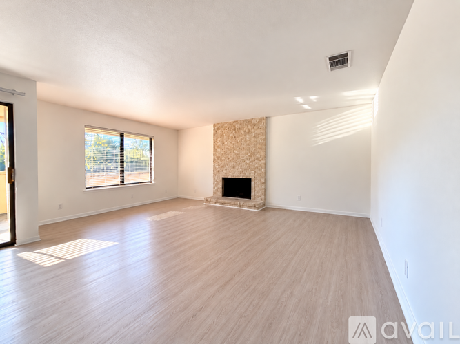 A spacious living room with a fireplace and hardwood flooring.